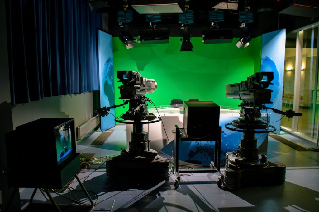 pexels-photo-7865064 A TV studio setup featuring cameras and a green screen for production purposes.